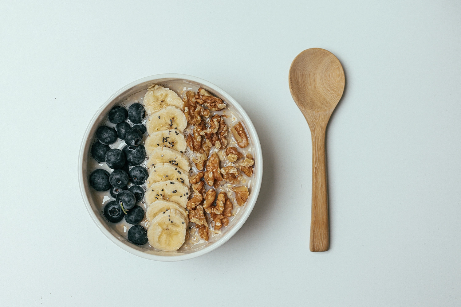 bowl filled with blueberries bananas, and walnuts